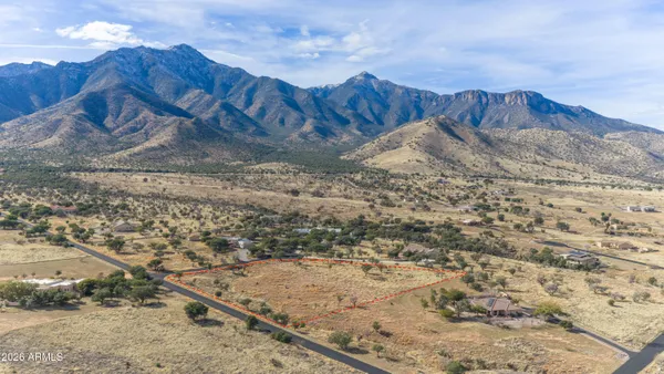 a view of a dry yard with wooden fence