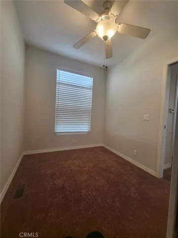 en empty room with windows and fan