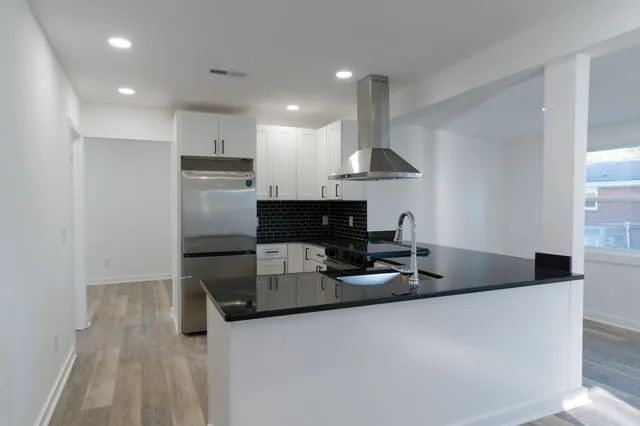 a kitchen with stainless steel appliances granite countertop a sink a stove a refrigerator and a cabinets