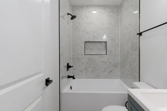 a bathroom with a sink and bathtub with toilet