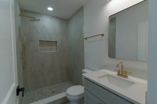 a bathroom with a sink a toilet and shower