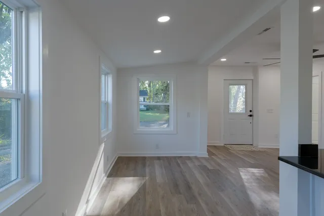 an empty room with wooden floor and windows