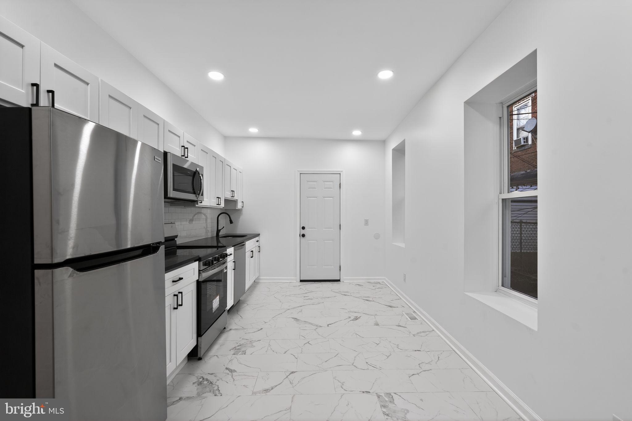 5311 Upland Street Philadelphia, PA 19143 - Photo 18 of 31 a kitchen with stainless steel appliances a refrigerator and a stove top oven