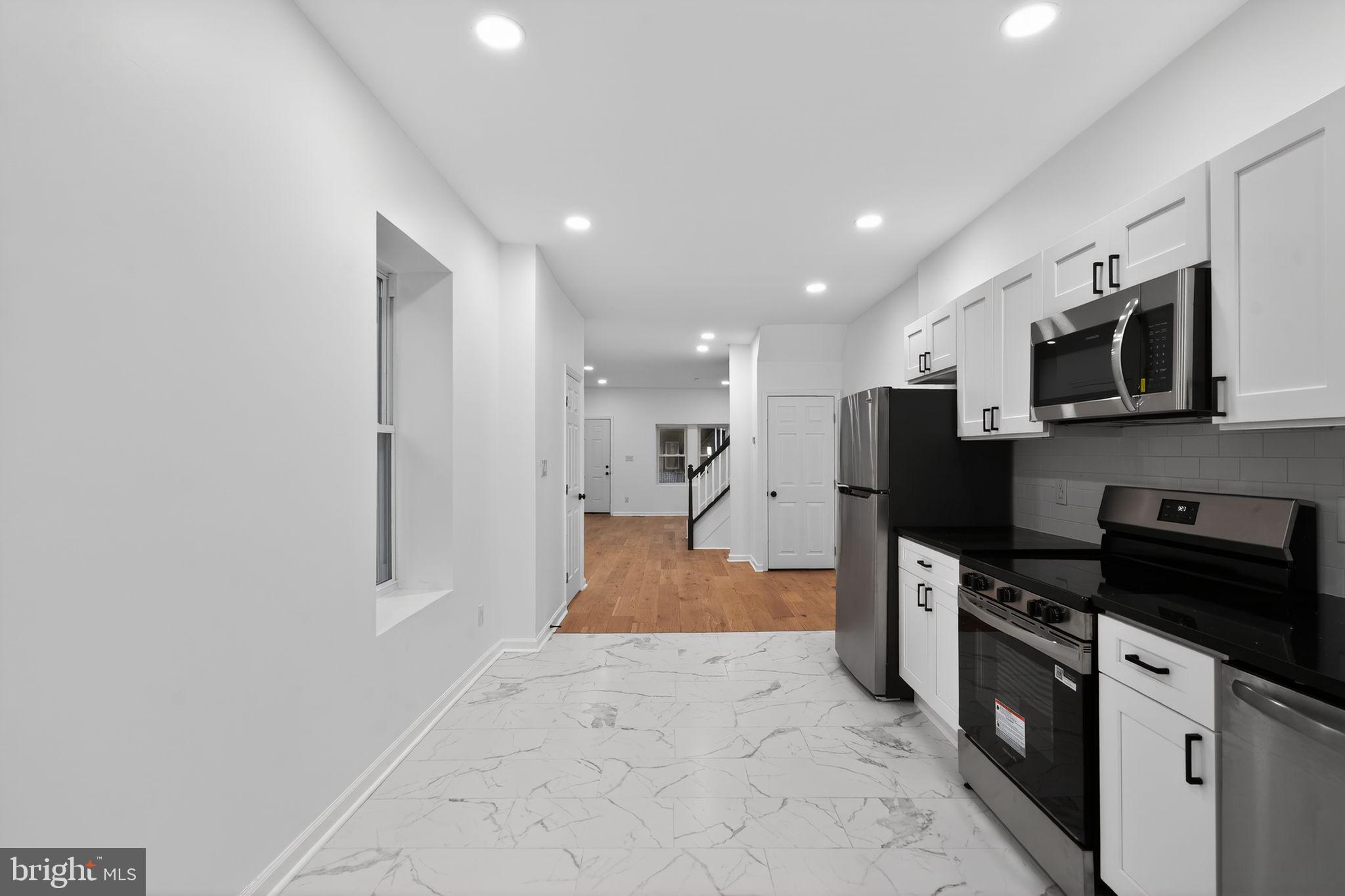 5311 Upland Street Philadelphia, PA 19143 - Photo 19 of 31 a view of kitchen with stainless steel appliances kitchen island sink refrigerator stove and microwave