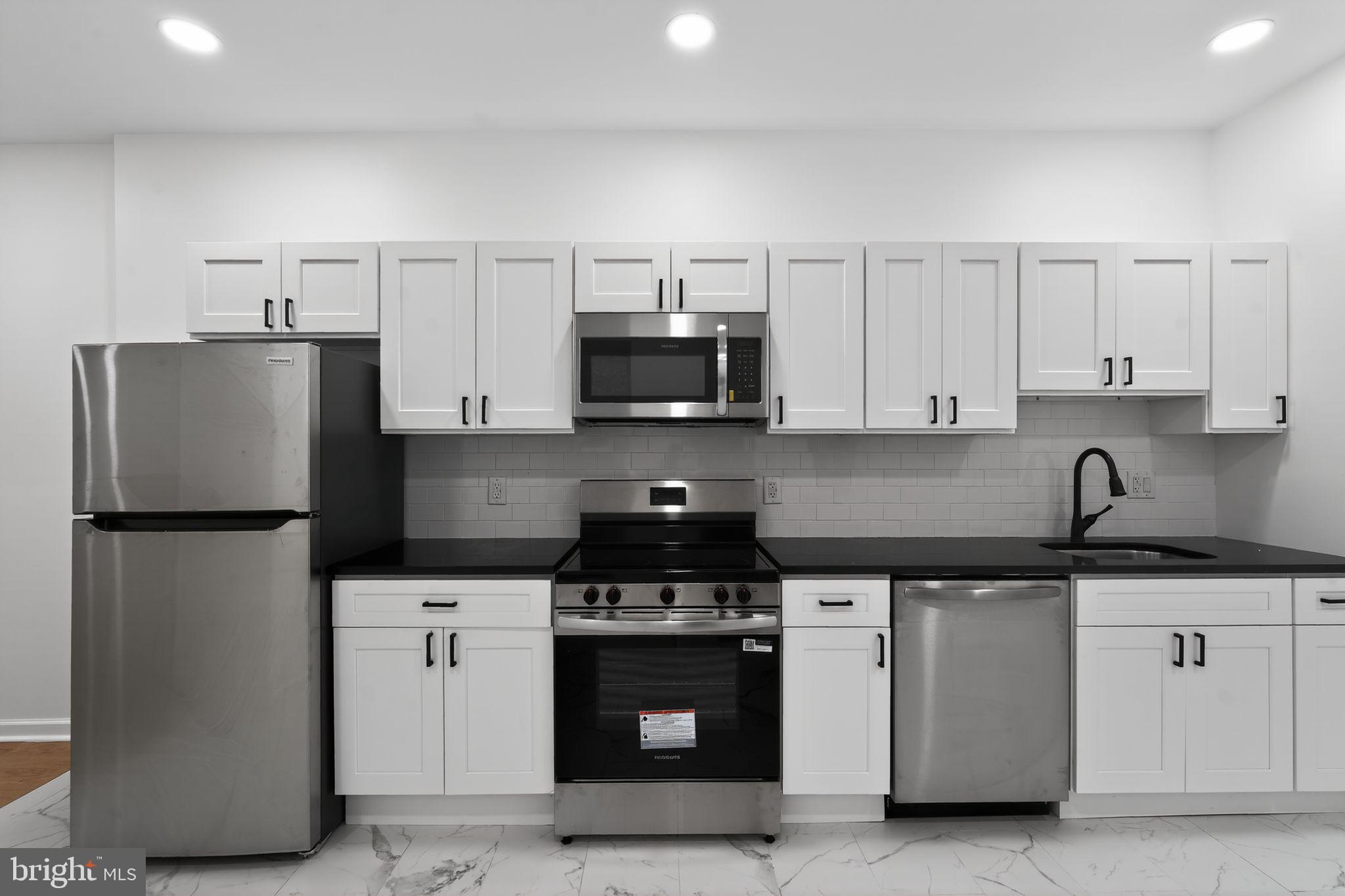 5311 Upland Street Philadelphia, PA 19143 - Photo 20 of 31 a kitchen with stainless steel appliances granite countertop white cabinets and a refrigerator