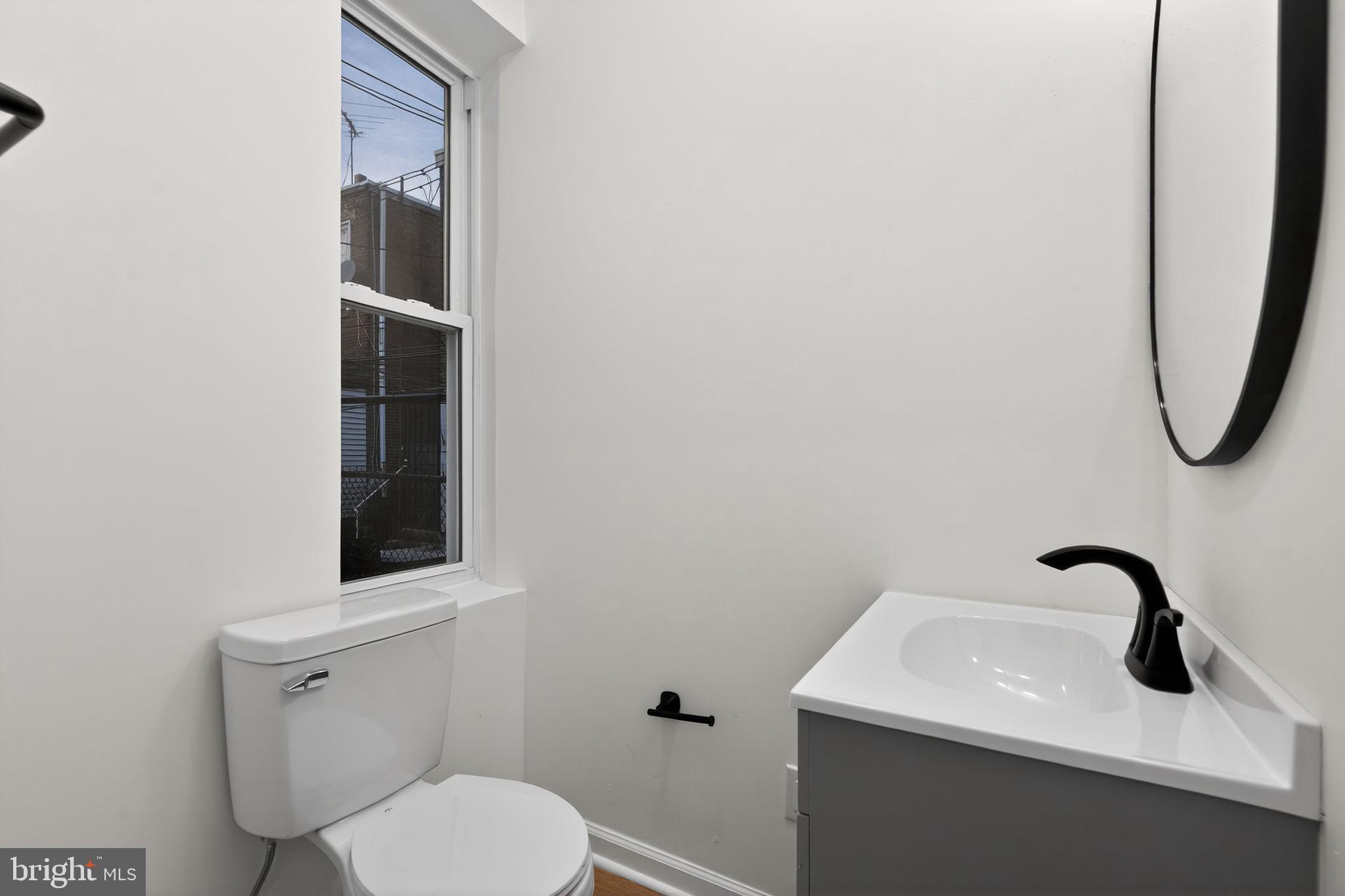 5311 Upland Street Philadelphia, PA 19143 - Photo 23 of 31 a bathroom with a toilet sink and mirror