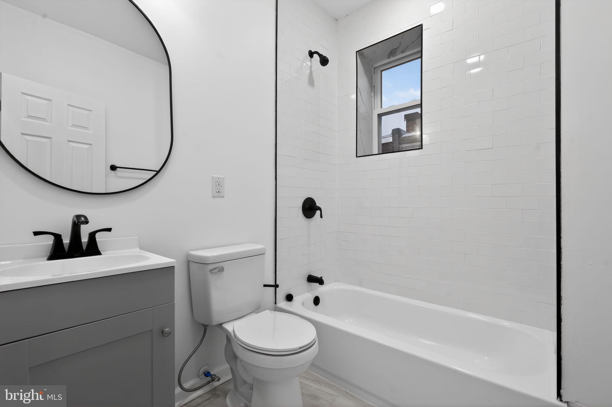 5311 Upland Street Philadelphia, PA 19143 - Photo 24 of 31 a bathroom with a bathtub sink mirror and toilet