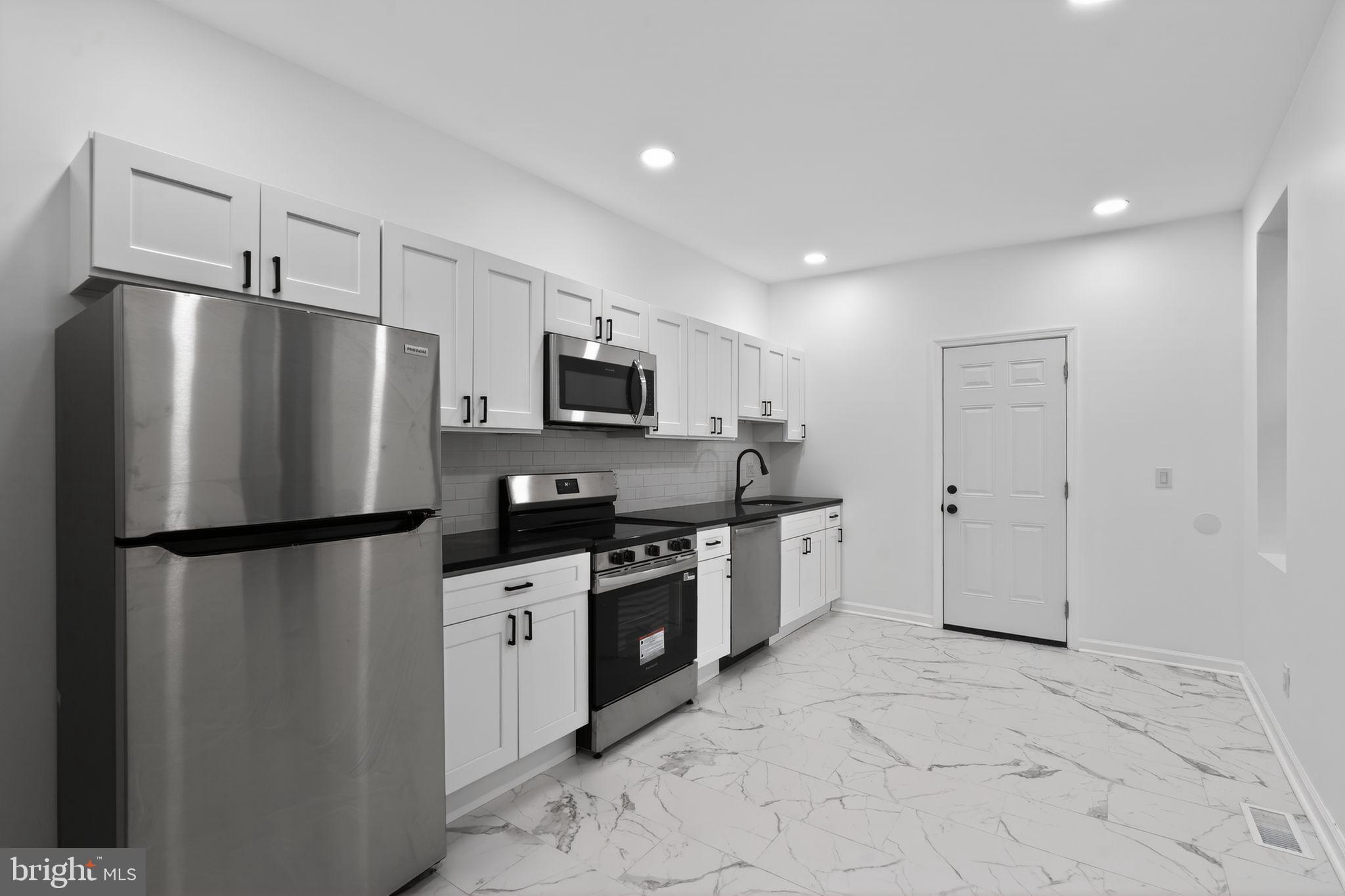 5311 Upland Street Philadelphia, PA 19143 - Photo 6 of 31 a kitchen with stainless steel appliances a refrigerator sink and microwave