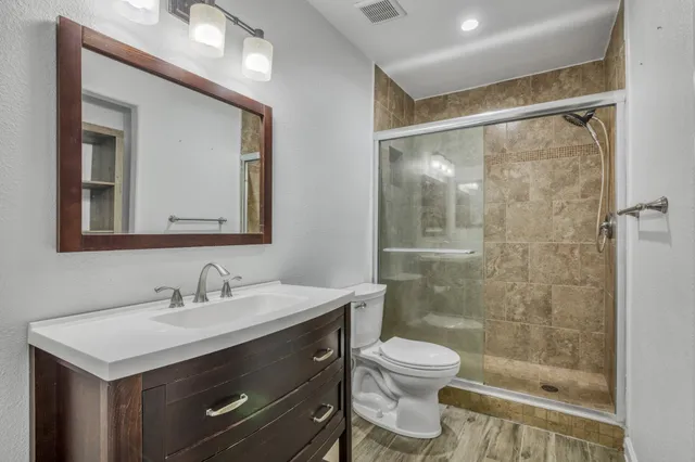 a bathroom with a sink toilet a mirror and shower