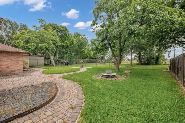 a view of a house with backyard and a tree