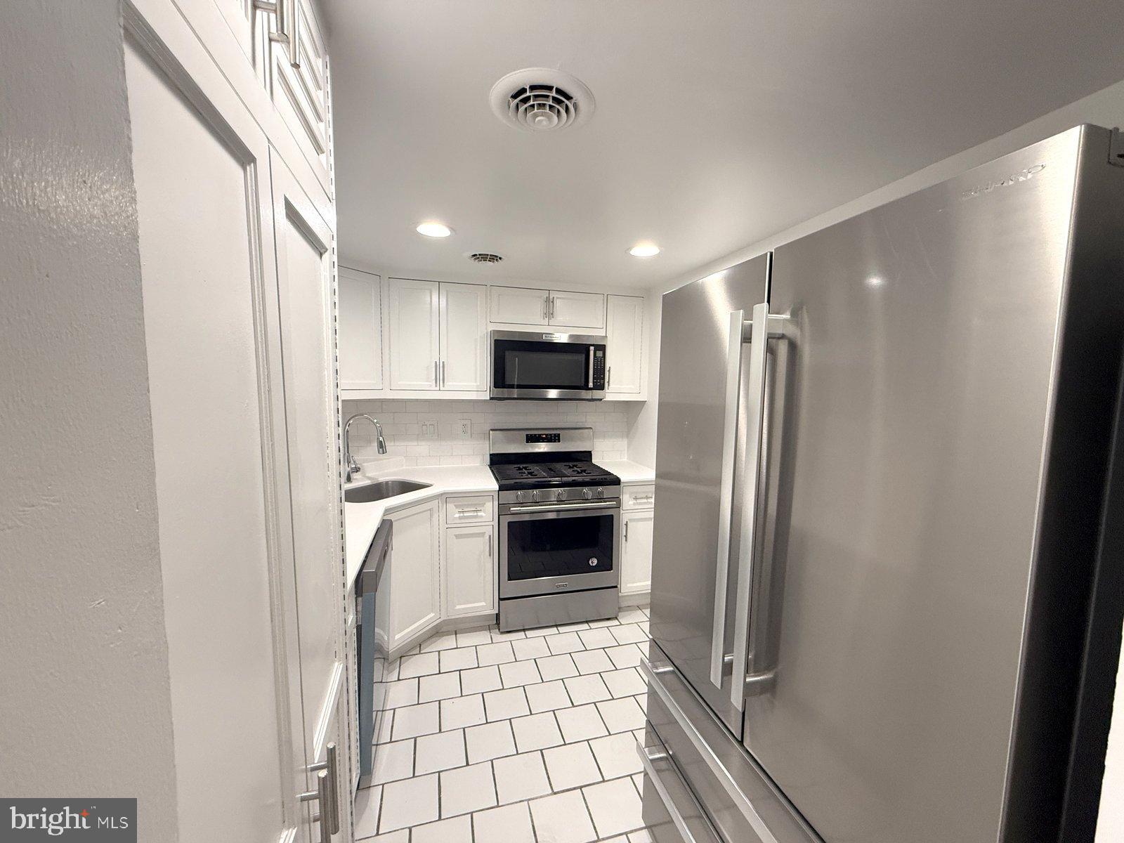 606 Cooper Landing Road, Unit B6L Cherry Hill, NJ 08002 - Photo 2 of 14 a kitchen with a refrigerator a stove top oven and a sink