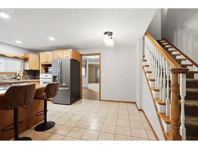 a kitchen with stainless steel appliances kitchen island granite countertop a refrigerator and a stove top oven