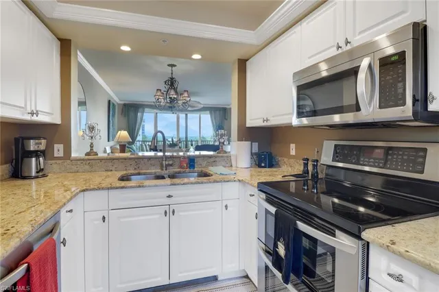a kitchen with granite countertop a sink dishwasher stove and cabinets with wooden floor