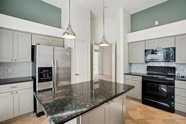 a kitchen with stainless steel appliances granite countertop a refrigerator a stove and a sink