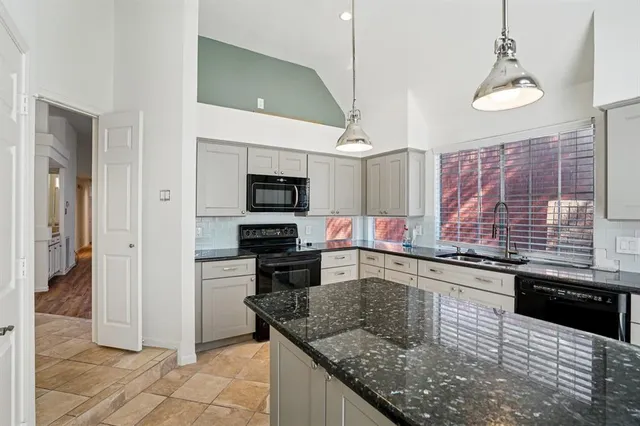 a kitchen with stainless steel appliances granite countertop a sink and a stove