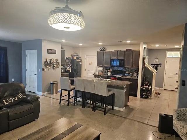 a living room with furniture and kitchen view