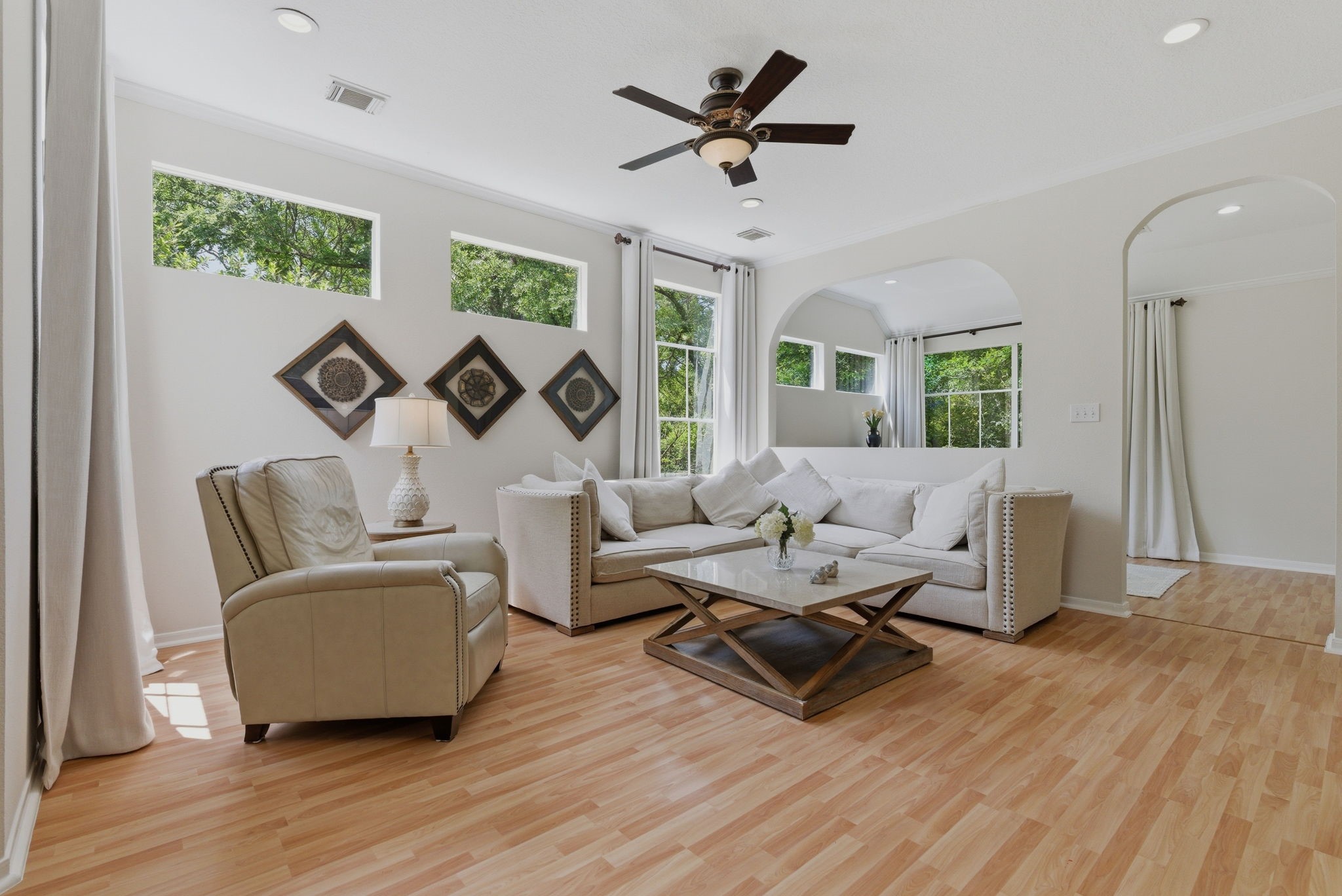 11 Dovewing Place Spring, TX 77382 - Photo 10 of 32 Main floor, inviting living room with large windows, light wood flooring, and a modern ceiling fan. Perfect for relaxing and entertaining.