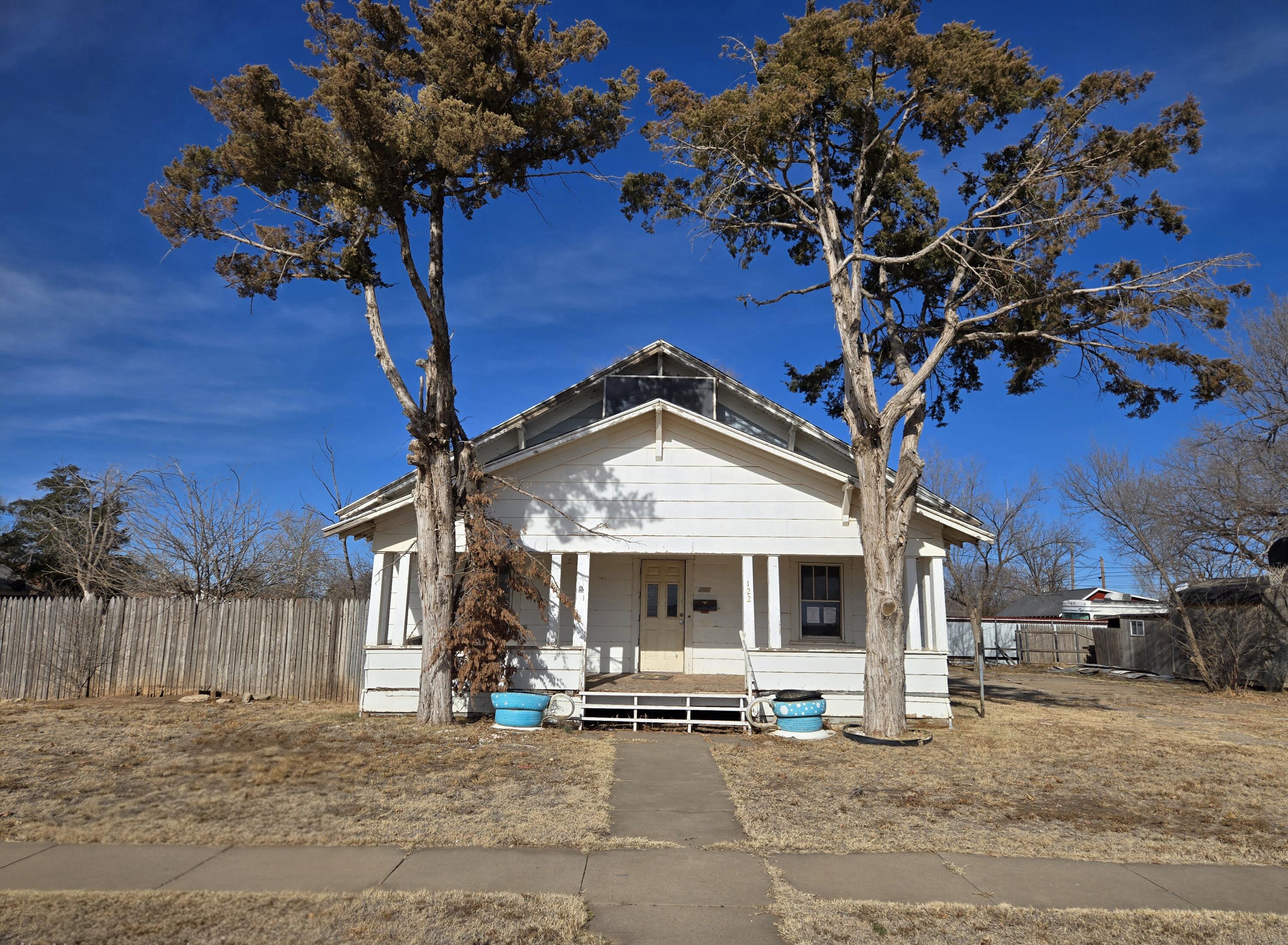 a front view of a house with a tree
