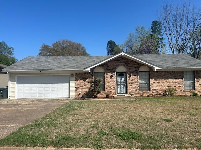 Ranch-style house with brick siding, driveway, a garage, and a front lawn