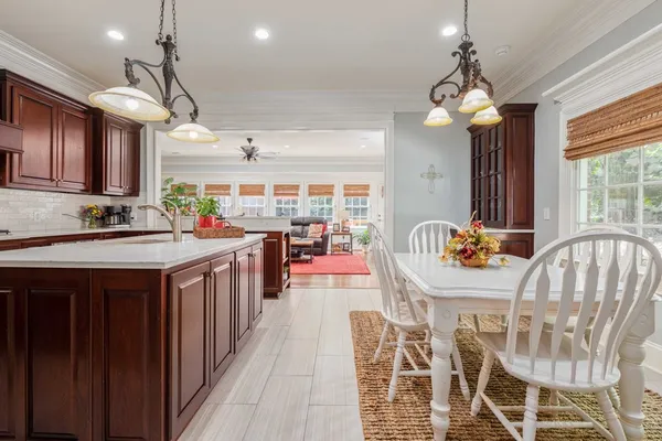 a dining room with wooden floor a chandelier a wooden table and chairs