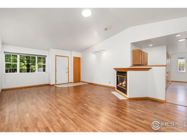a view of empty room with wooden floor and window
