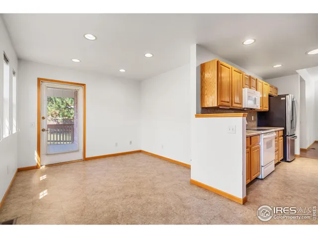 a view of kitchen with stainless steel appliances granite countertop a stove a sink and a microwave