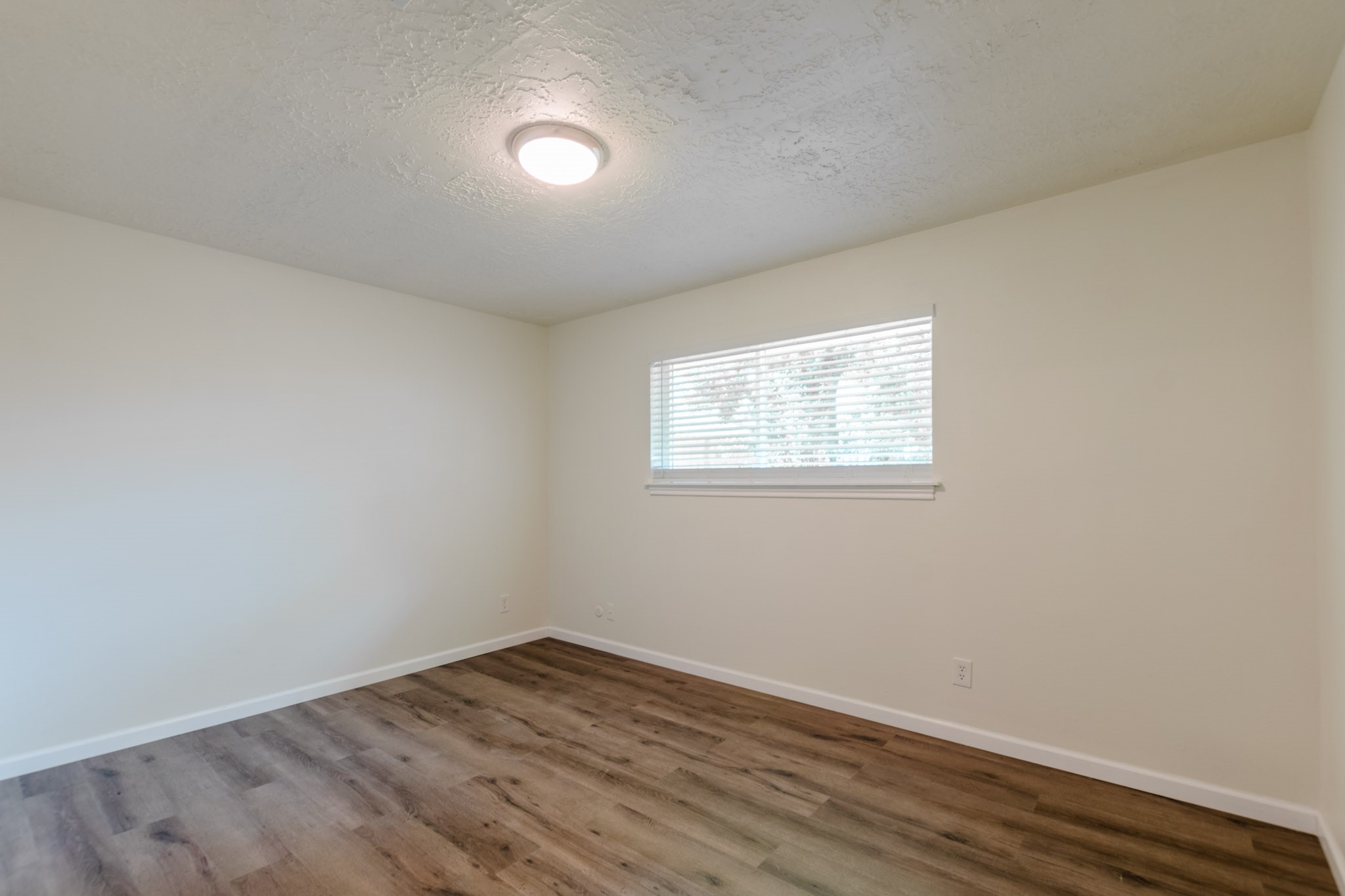 9646 Springview Lane Houston, TX 77080 - Photo 18 of 32 an empty room with wooden floor and windows