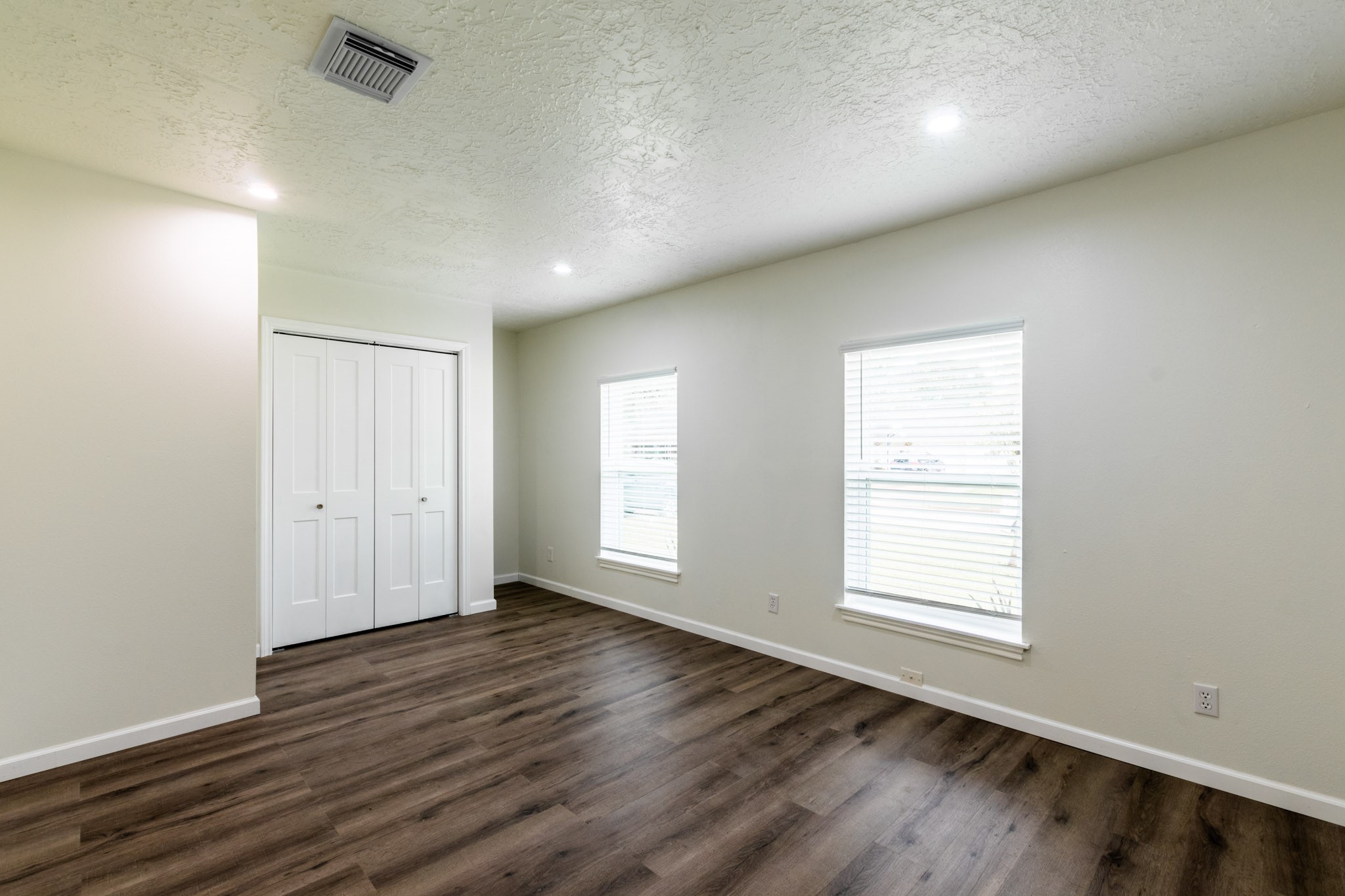 9646 Springview Lane Houston, TX 77080 - Photo 4 of 32 an empty room with wooden floor and windows