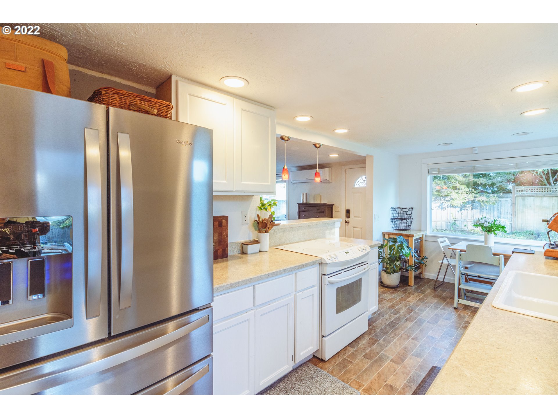 11910 Southwest Denney Road Beaverton, OR 97008 - Photo 5 of 22 a kitchen with a sink a refrigerator and chairs