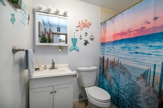 a bathroom with a granite countertop sink a toilet and a mirror