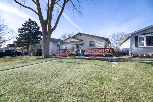 a view of a house with a big yard and large trees