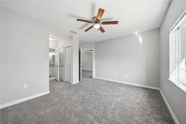 an empty room with closet and windows