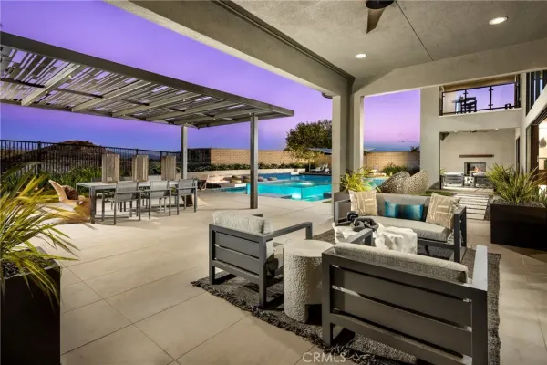 a view of a patio with dining table and chairs under an umbrella