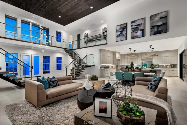 a living room with furniture kitchen view and a large window