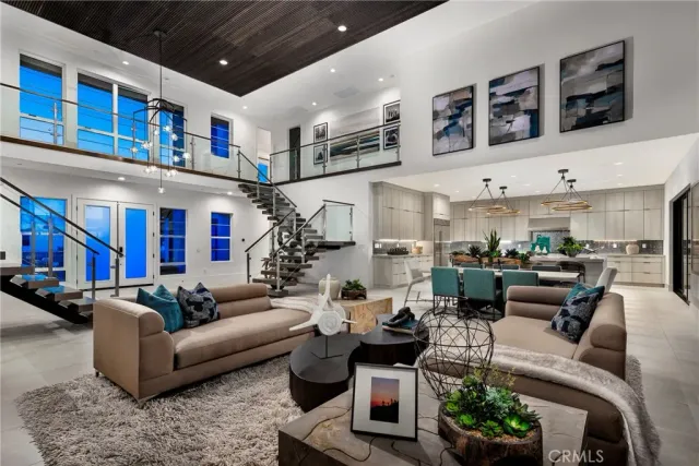 a living room with furniture kitchen view and a large window