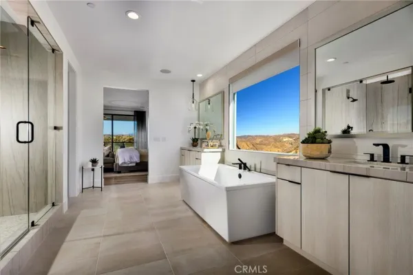 a spacious bathroom with a double vanity sink a mirror and a shower