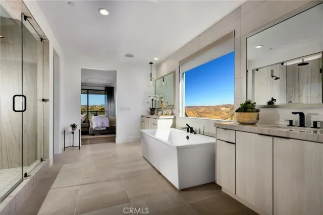 a spacious bathroom with a double vanity sink a mirror and a shower