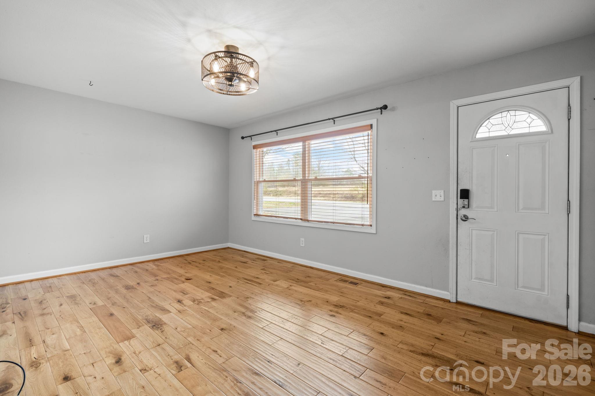 309 Sheldon Street Hudson, NC 28638 - Photo 4 of 35 a view of an empty room with window and wooden floor