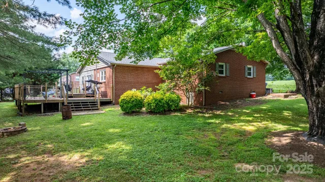 a view of a house with a backyard and a tree