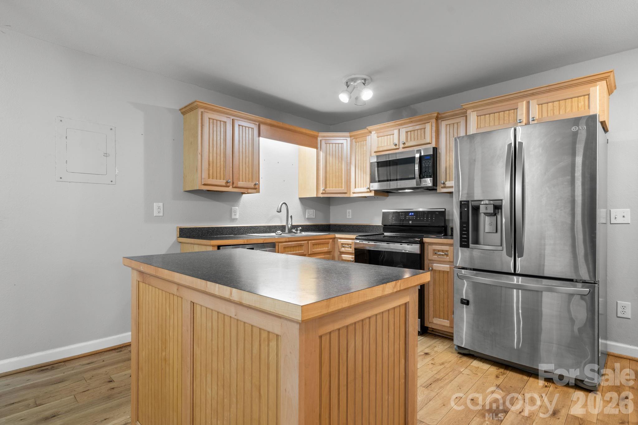 309 Sheldon Street Hudson, NC 28638 - Photo 5 of 35 a kitchen with stainless steel appliances granite countertop a refrigerator a sink a stove a microwave and wooden floors