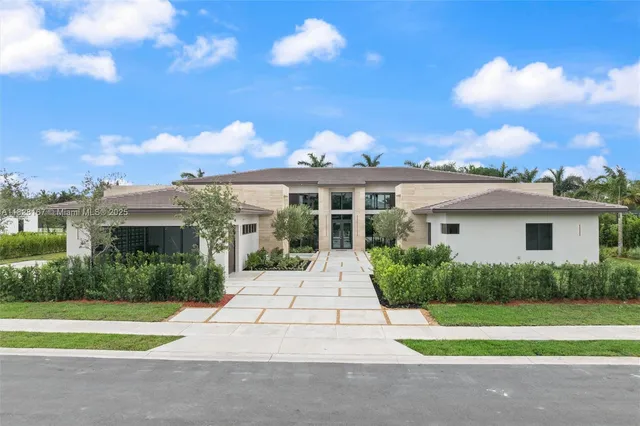 a front view of a house with a yard and potted plants