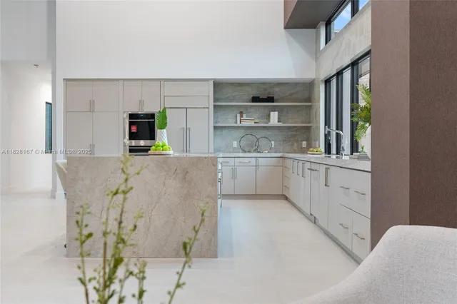 a large kitchen with stainless steel appliances a sink and cabinets