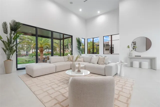 a living room with furniture and large windows