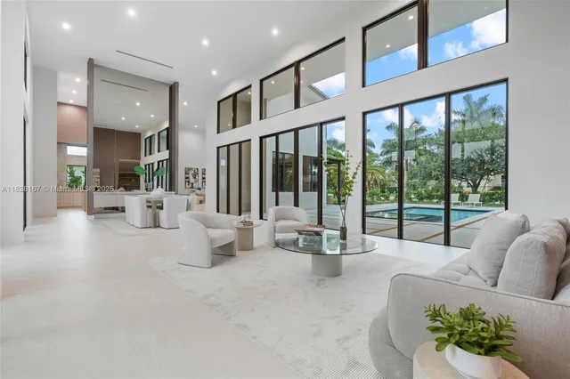 a living room with furniture a potted plant and a large window