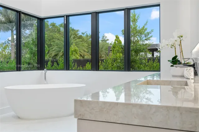 a bathroom with a granite countertop sink mirror and bathtub