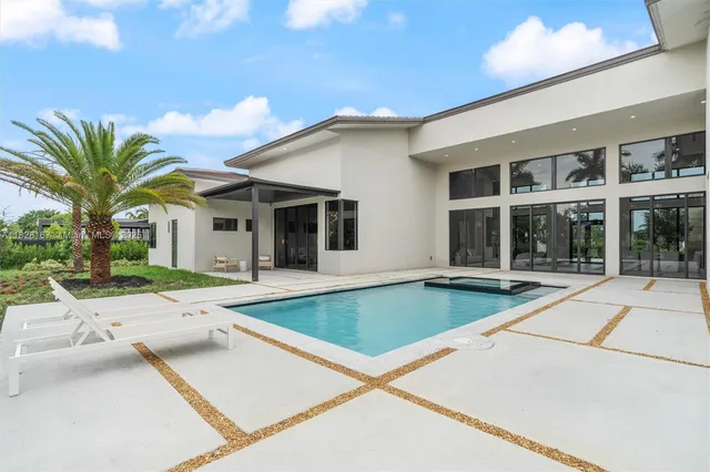 a view of a house with pool and sitting area