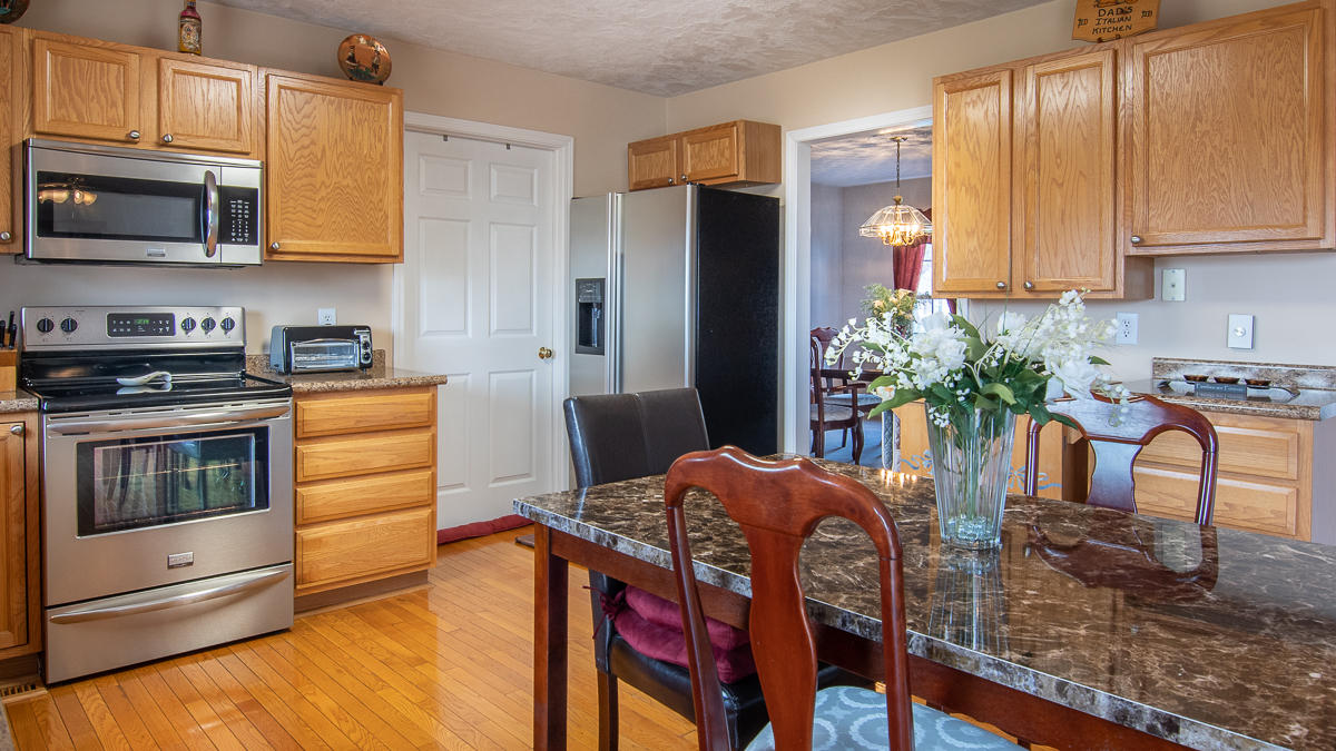 112 Aftons Meadow Road Vinton, VA 24179 - Photo 13 of 46 a kitchen with stainless steel appliances granite countertop a stove a refrigerator a microwave a sink and chairs