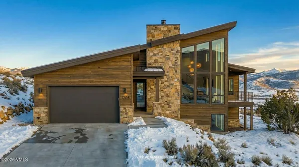 a front view of a house with a yard covered in snow