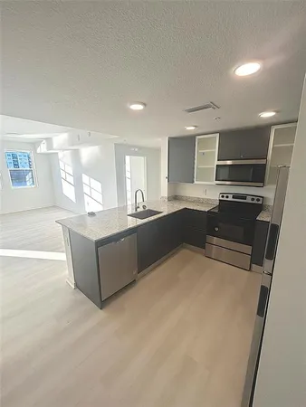 a large kitchen with kitchen island a sink stainless steel appliances and a window