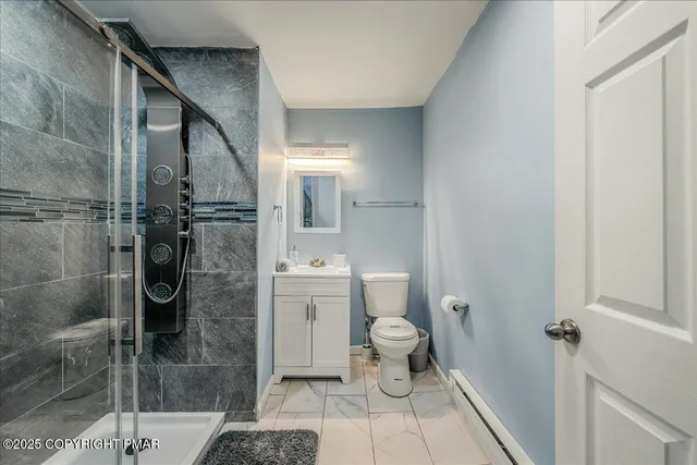 a bathroom with a granite countertop shower a toilet and a sink